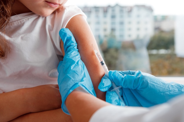 Docteur vaccinant le petit enfant dans la clinique moderne