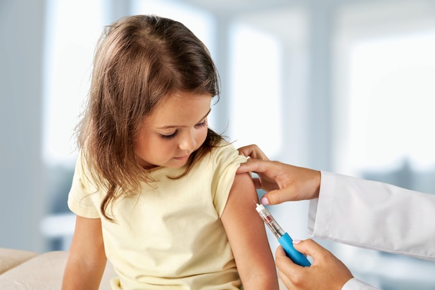 Docteur vaccination petite fille isolée sur fond