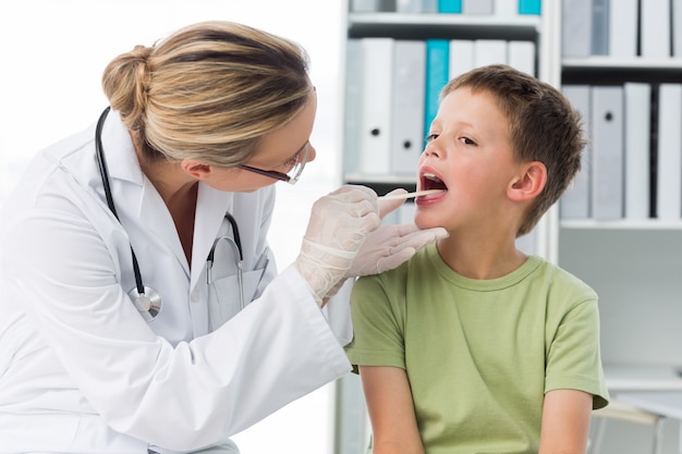 Docteur vérifiant la bouche du garçon