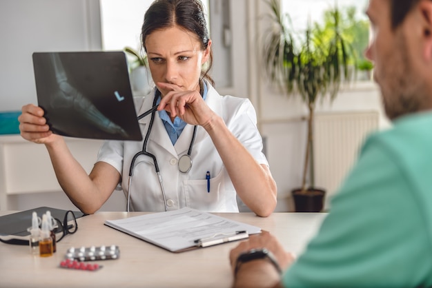 Docteur vérifiant la radiographie de la cheville