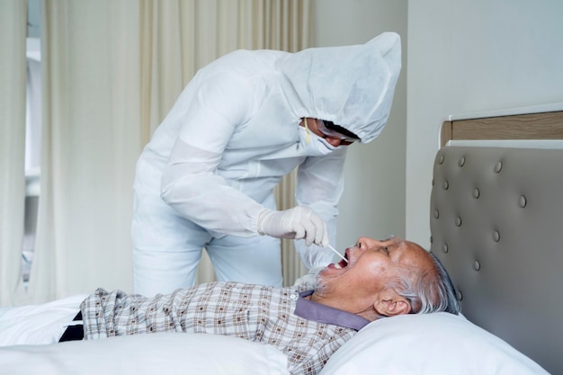 Le docteur vérifie la bouche de ses vieux patients sur un lit.