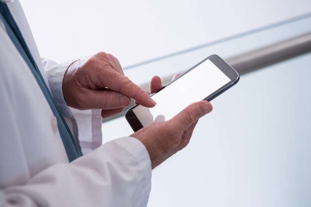 Photo doctor holding smartphone dans le passage à l'hôpital