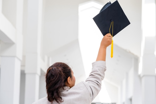 Des doctorantes portant des casquettes de graduation noires à glands jaunes sont à l'université.