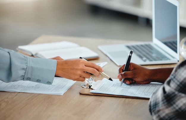 Document contractuel et papier gros plan du banquier avec le client signant par écrit ou remplissant des informations sur le formulaire d'assurance ou de prêt Employé de banque donnant des instructions au client sur l'accord de droit bancaire