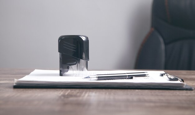 Document, stylo et tampon sur la table.