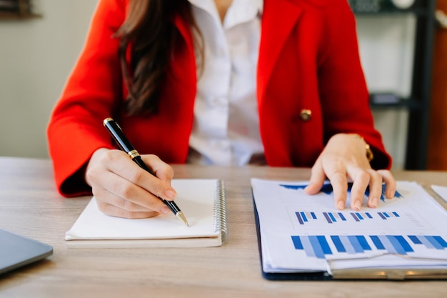 Documents d'affaires sur le bureau avec ordinateur portable et smartphone et diagramme d'entreprise graphique et homme travaillant le matin lightxA