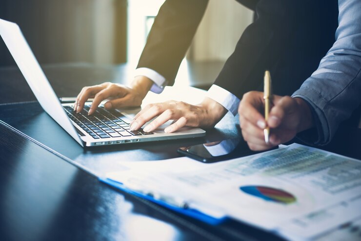 Photo documents d&#39;analyse de businesswomen sur le bureau avec ordinateur portable et graphique financier