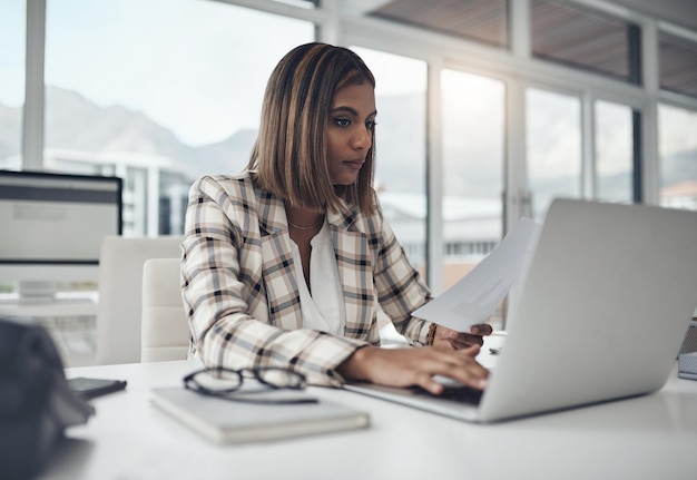 Photo documents de données d'ordinateur portable et femme tapant sur le lieu de travail de bureau pour les affaires ordinateur d'analyse de la paperasserie et personne de sexe féminin lisant des informations pour analyser des graphiques ou des graphiques d'analyse pour les statistiques financières