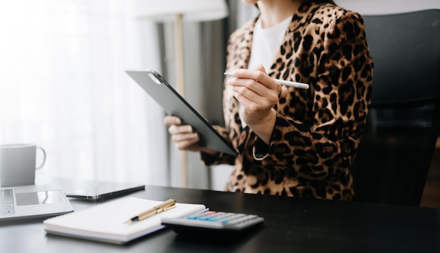 documents d'une femme d'affaires sur un bureau avec un ordinateur portable et un téléphone intelligent et un diagramme d'affaires graphique et un homme travaillant dans la lumière du matin