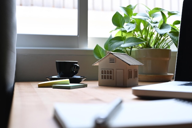 Documents modèles de maison et ordinateur portable sur une table en bois Concept d'investissement hypothécaire et immobilier