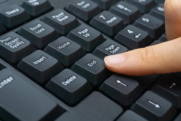 Le doigt d'une femme tenant un clavier d'ordinateur