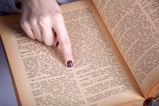 Doigt de femmes pointant sur la page du livre. Fermer la vue.