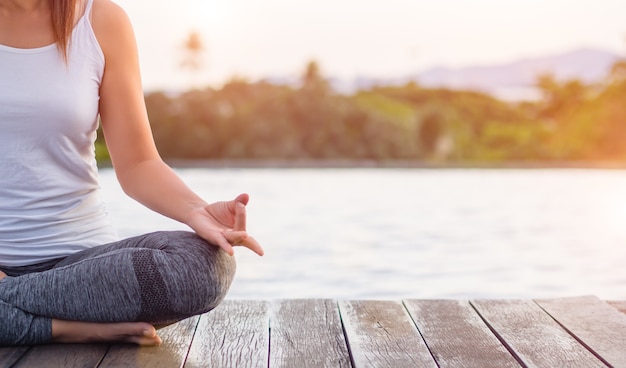 Doigt de yoga femme agissant sur les mains avec la nature entourant le fond.