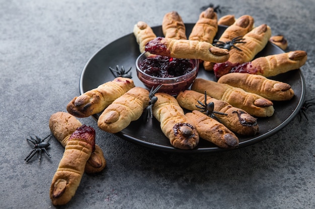 Doigts de biscuits sanglants pour la célébration de la fête d'Halloween, Cookies "Doigts de sorcières". Fond sombre, nourriture pour Halloween