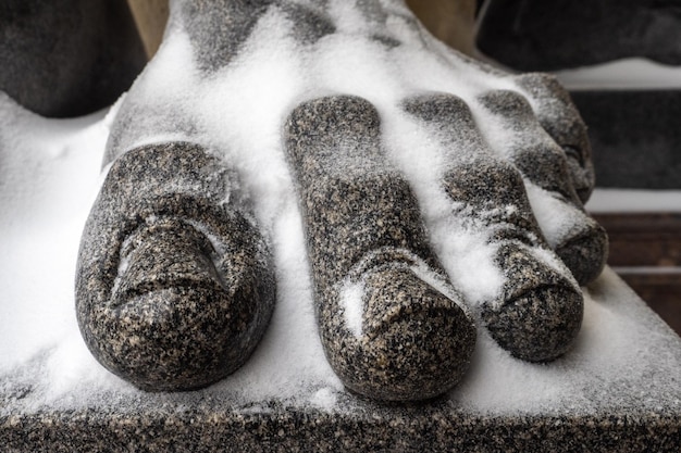 Photo des doigts couverts de neige d'une statue près de la place dvortsovaya