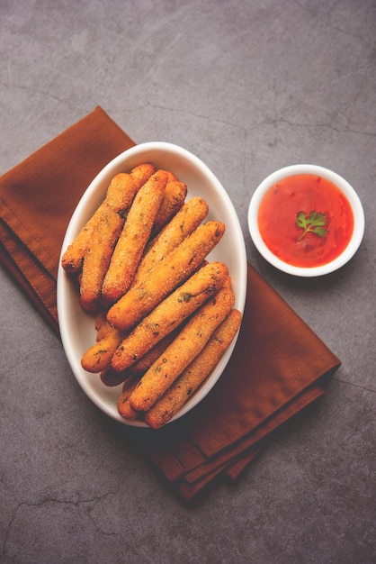 Doigts croustillants de Rava Aloo ou Bâtonnets frits de semoule de pomme de terre servis avec du ketchup