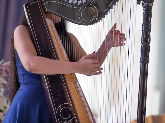 doigts féminins jouant de la harpe