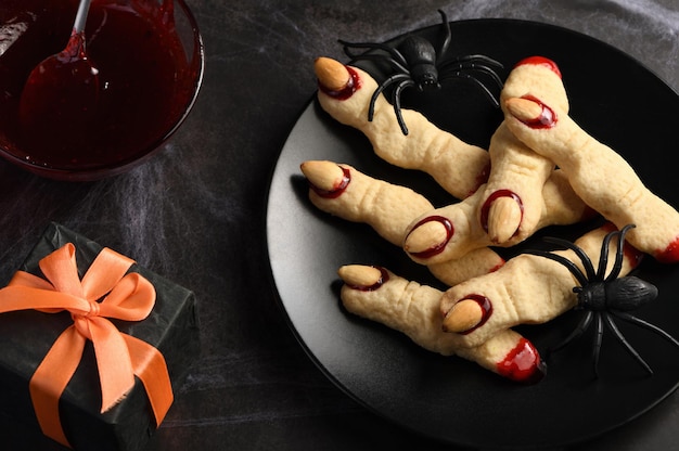 Photo des doigts de sorcière effrayants et effrayants à base de biscuits au sucre avec de la confiture de framboises et des amandes pour halloween trickortreat classic cookie witch fingers prend un look paléo végétalien sain et sans gluten