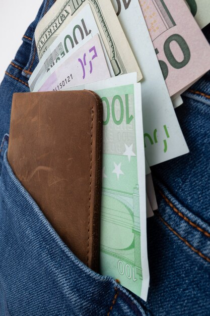 Dollars et euro sortant de la poche de jeans