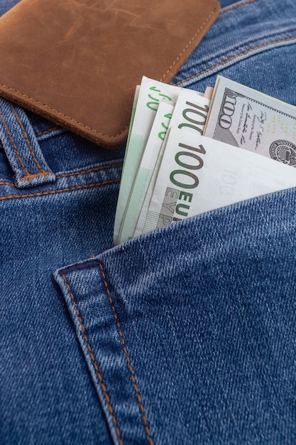 Dollars et euro sortant de la poche de jeans