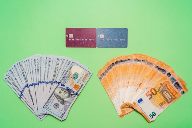 Des dollars et des euros en espèces avec des cartes de crédit sur fond vert