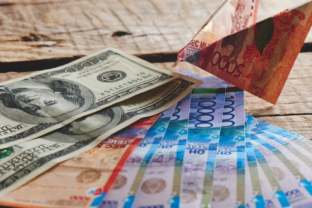 Dollars et tenge sur un fond en bois. Monnaie du Kazakhstan. Affaires et argent.