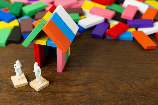 Le domino multicolore construit la maison sur la table en bois.