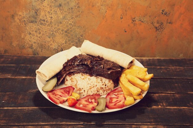 Doner kebab est allongé sur la planche à découper Shawarma avec salade d'oignons à la viande se trouve sur un vieux bois sombre