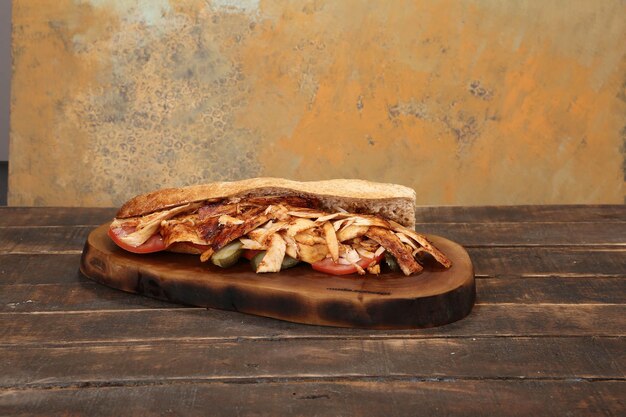 Doner kebab est allongé sur la planche à découper Shawarma avec salade d'oignons à la viande se trouve sur un vieux bois sombre