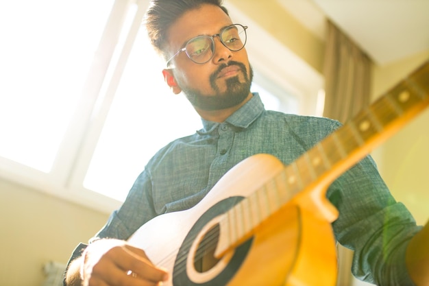 Donner des cours de guitare en ligneL'homme indien joue de la guitare