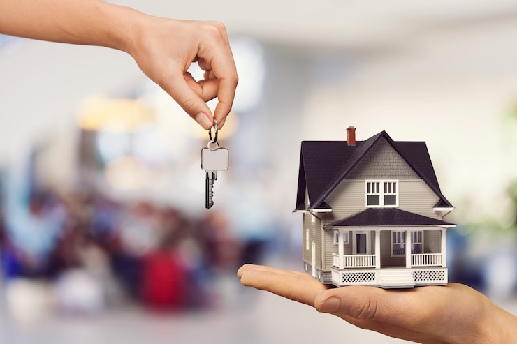 Photo donner à la main des clés de maison en métal et une mini maison