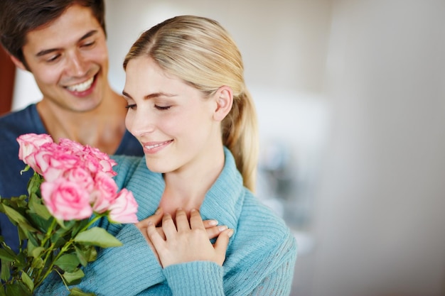 Donnez-lui des roses juste parce que Photo d'un jeune homme affectueux donnant à sa belle jeune femme un bouquet de roses roses