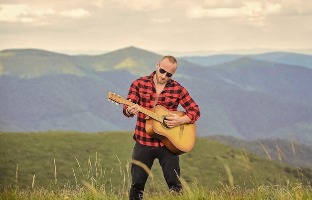 Donnez vie à la musique homme cow-boy avec joueur de guitare acoustique chanson de musique country homme sexy avec guitare en chemise à carreaux hipster mode western camping et randonnée heureux et libre