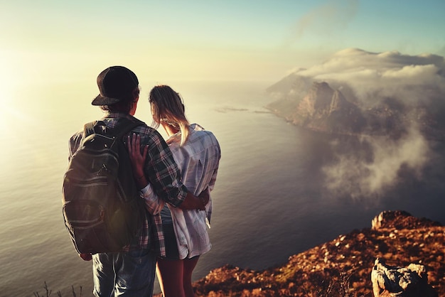 Donnez votre cœur mais gardez-le sauvage Vue arrière d'un jeune couple non identifiable admirant la vue depuis un sommet de montagne ensemble