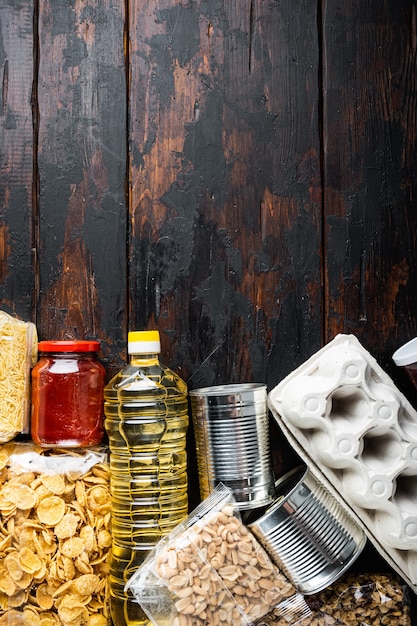 Photo dons ensemble alimentaire de produits de base et de plats en conserve, mise à plat, sur table en bois