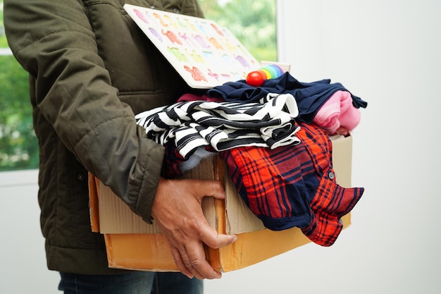 Dons de vêtements dans une boîte en carton pour un bénévole