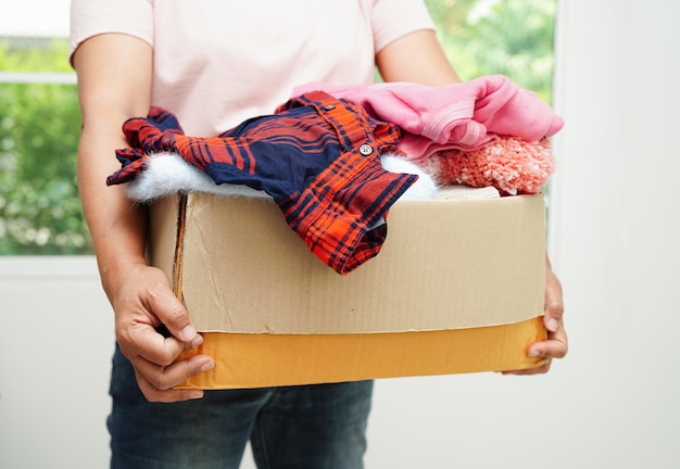 Dons de vêtements dans une boîte en carton pour un bénévole