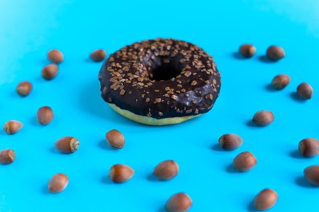 Donut aux noisettes sur fond bleu, gros plan