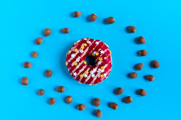 Donut aux noisettes sur fond bleu, gros plan