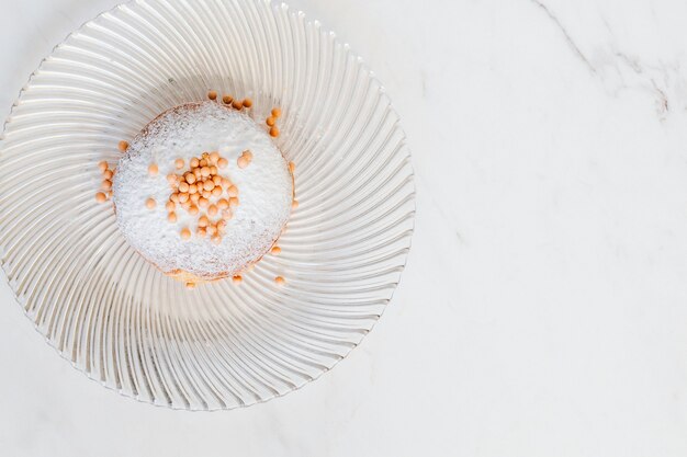 Donut décoré de vermicelles sur une table blanche