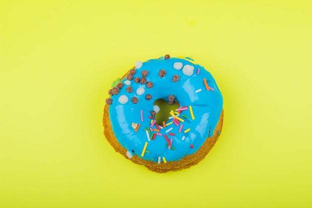 Donut avec glaçage bleu sur fond jaune