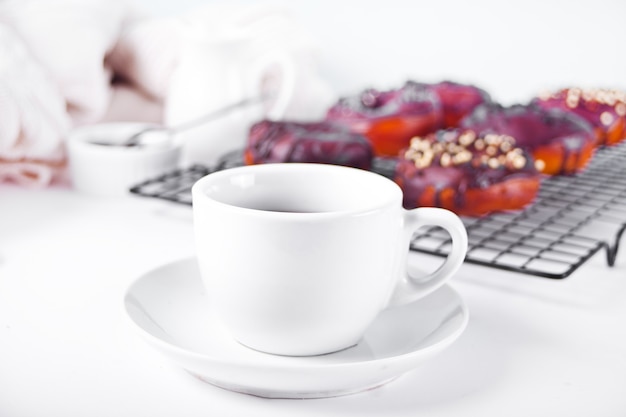 Donut glacé avec de la crème au chocolat ou du glaçage et une tasse de café. Concept de petit déjeuner.