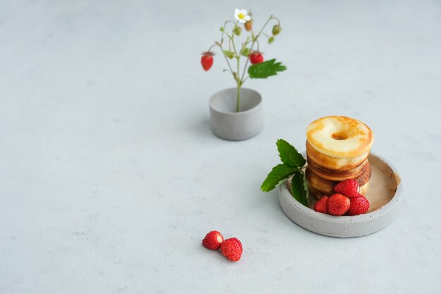 Donut rond au four avec des fraises sur fond de béton. Minimalisme.