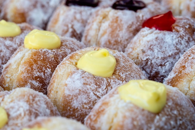 Donuts au marché alimentaire de rue en Thaïlande, gros plan. Beignets savoureux avec confiture, chocolat et lait concentré