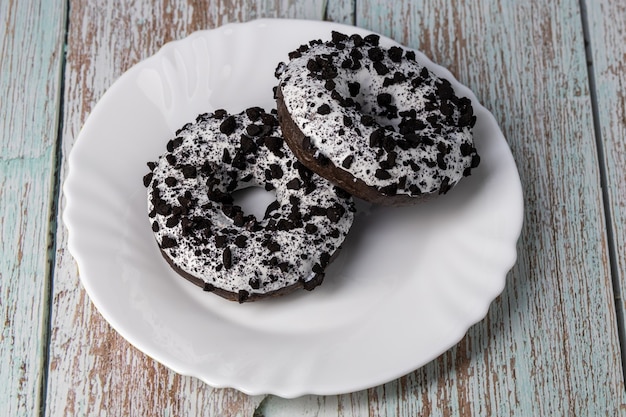 Donuts sur une plaque blanche sur une table en bois