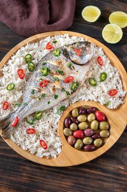 Dorada grillée garnie de riz blanc et olives marinées