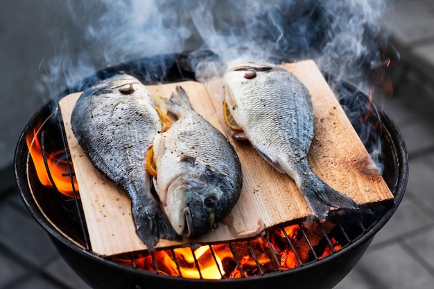 Photo dorado au citron cuisson sur grill avec planche de cèdre