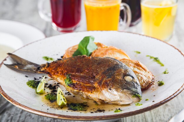 dorado frit sur une assiette avec sauce aux légumes cuits