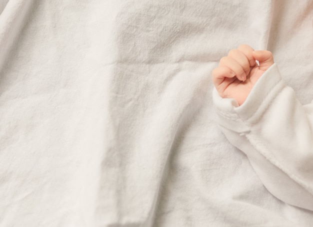 Dormir bébé nouveau-né dans une enveloppe sur une couverture blanche