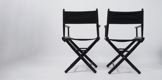 Dos d'une chaise noire à deux réalisateurs utilisée dans la production vidéo ou l'industrie du cinéma et du cinéma sur fond blanc.